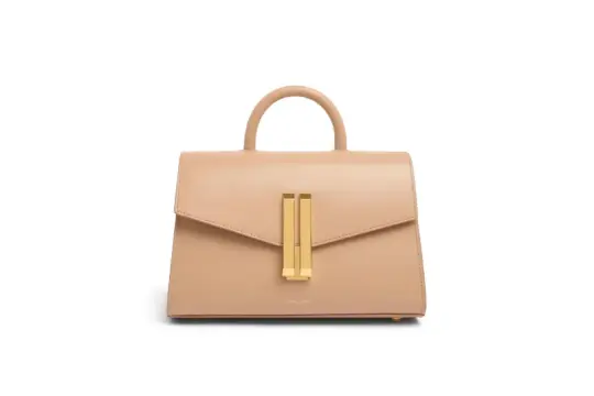 A beige leather handbag with a top handle and gold hardware.
